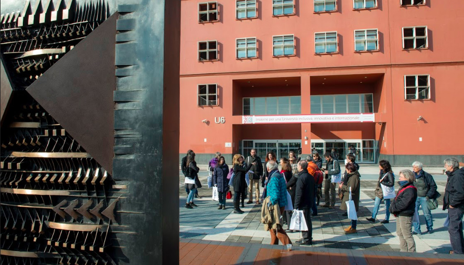 folla in piazza davanti alla scultura di Pomodoro