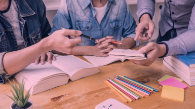 studenti intorno a un tavolo con libri e tablet