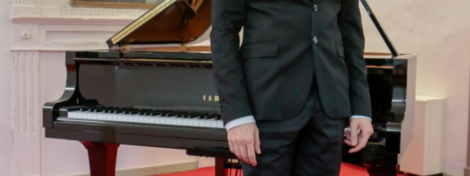 uomo in piedi davanti al pianoforte