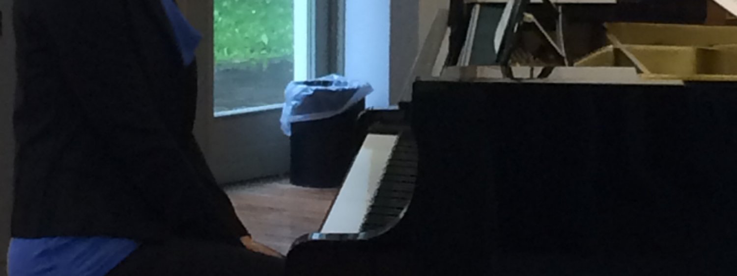 ragazza che suona seduta al pianoforte