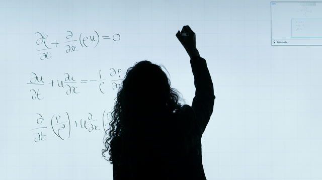 Matematica che scrive alla lavagna