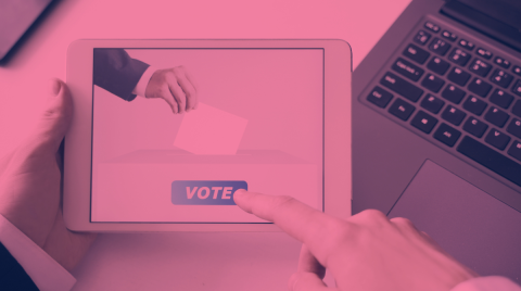 schermo di tablet con la scritta VOTE e dito che clicca sulla scritta