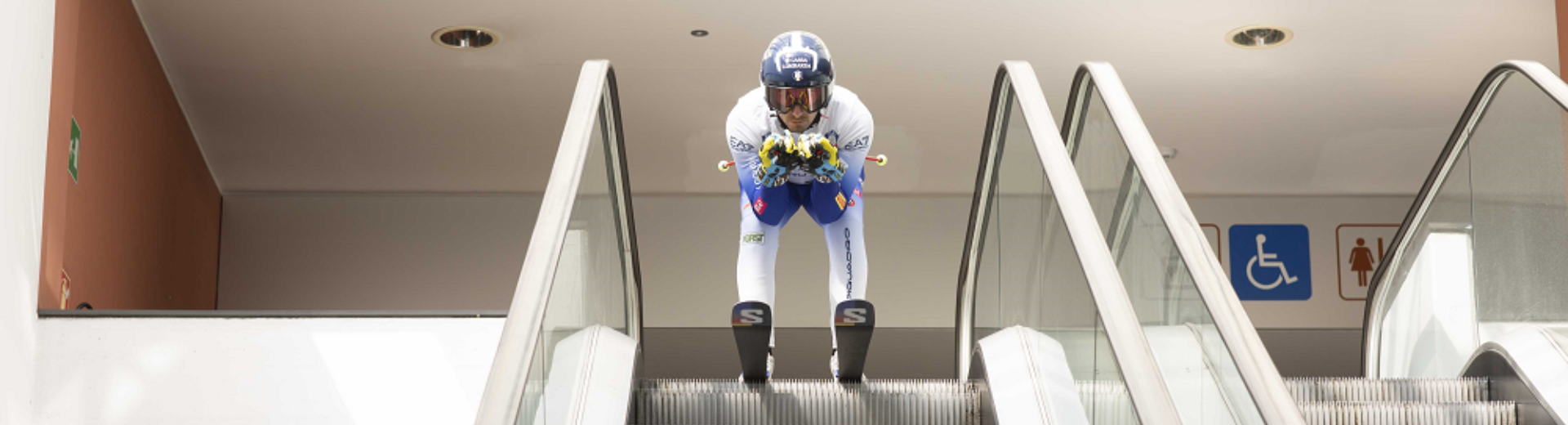 Pietro Zazzi con gli sci sulle scale mobili in Università Bicocca 